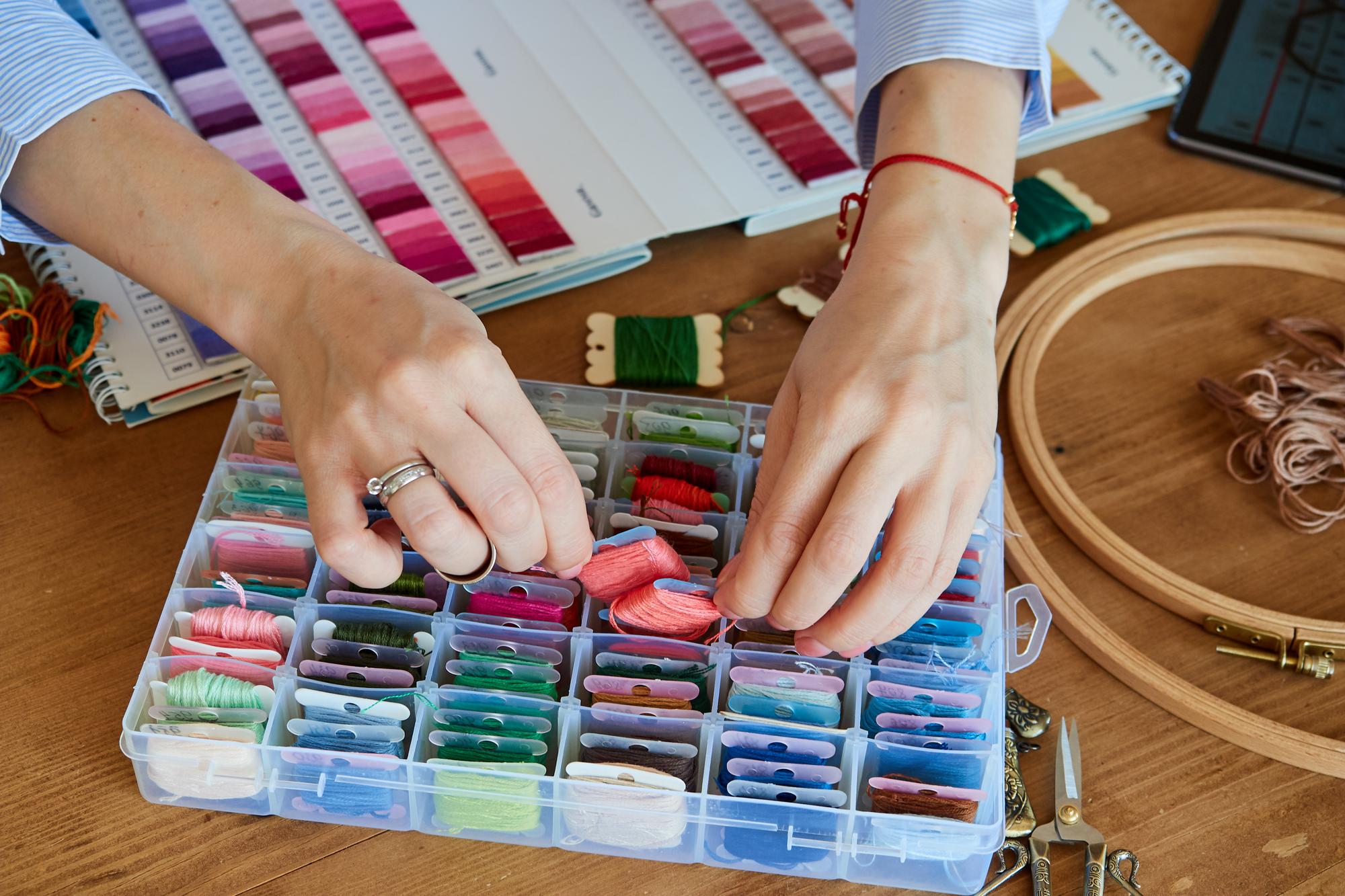 hands selecting thread colours on a table